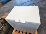 a white refrigerator sitting on a pallet in a warehouse