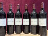 six bottles of red wine are lined up on a wooden table