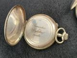 three different types of pocket watches on a black surface