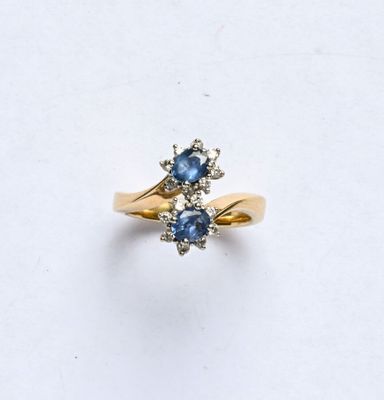 une photo d'une bague sertie d'un diamant et d'un saphir sur un fond blanc