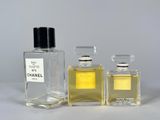 two bottles of perfume sitting next to each other on a table