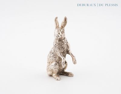 un gros plan d'une figurine de lapin en argent sur fond blanc