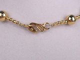 an image of a necklace with gold beads on a mannequin