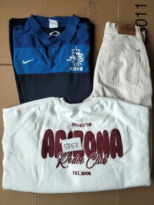 Deux paires de pantalons blancs et une chemise bleue se trouvent dans une boîte en carton
