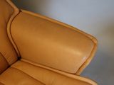 a brown leather chair that is sitting in a room