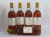 quatre bouteilles de vin posées les unes à côté des autres sur une surface blanche