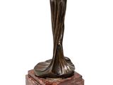 bronze statue of a woman holding a hat on a marble base