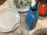 many plates and bowls on a table with a pitcher