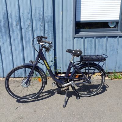 un vélo noir garé devant un immeuble bleu