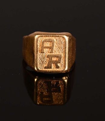 a close up of a gold signet ring on a black surface