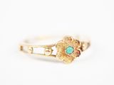 gros plan d'une bague en or avec une pierre turquoise