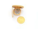 an image of a gold pocket watch and a coin on a white surface