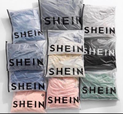 six bags of different colored shirts on a white surface