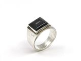 a close up of a silver ring with a black stone on it