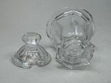 a glass bottle and a glass candle holder on a table