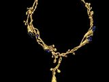 a gold and lapis necklace with a blue stone pendant