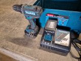 une perceuse sans fil et deux batteries dans une boîte bleue