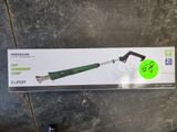 une boîte munie d'une poignée verte, posée sur un sol carrelé