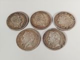 quatre pièces de monnaie britanniques différentes sont représentées en rangée sur un fond blanc