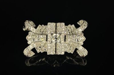 Broche en or blanc et en platine à décor de volutes ornée d'un diamant - Photo 1