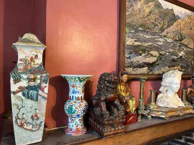 de nombreux vases et statues posés sur une étagère dans une pièce