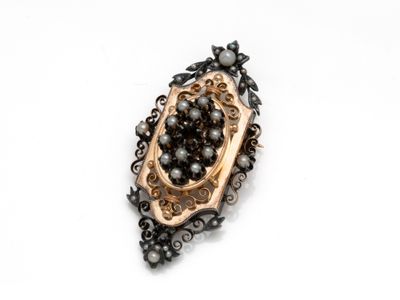 a close up of a black and gold broochle on a white surface