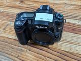 a camera sitting on a wooden table with a tag on it
