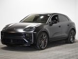 Une Porsche Cayenne grise est garée dans une pièce blanche