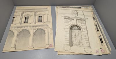 deux anciens plans architecturaux d'un bâtiment posés sur une table