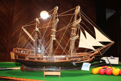 une maquette de bateau posée sur une table, avec des boules de billard