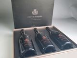 three bottles of wine in a box on a table