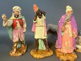 three figurines of three men and a dog on a table