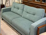 a blue couch sitting in front of a glass cabinet