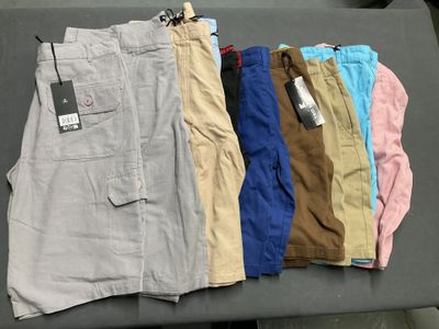 plusieurs paires de shorts pour homme posées sur une table, avec une étiquette de prix