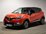 La voiture orange est garée dans le garage, sur le sol à damier.
