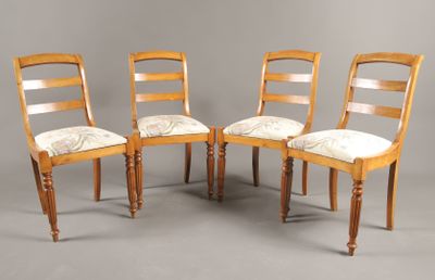 On voit trois chaises en bois avec des assises rembourrées sur un fond gris