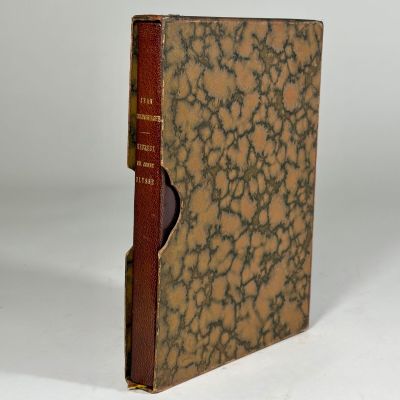 un vieux livre à la couverture marron posé sur une table blanche