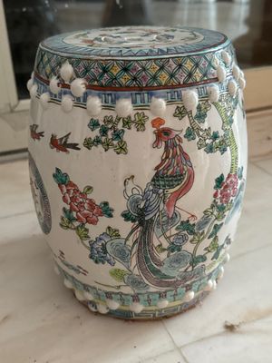 un vase blanc orné d'un paon, posé sur une table