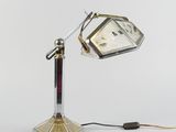 une lampe posée sur un pied sur lequel se trouve une horloge