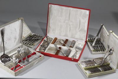 plusieurs pièces d'argenterie dans un coffret posé sur une table