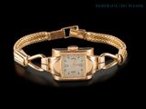 an image of a gold wrist watch with a chain around it