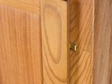 a close up of a wooden cabinet with a door handle