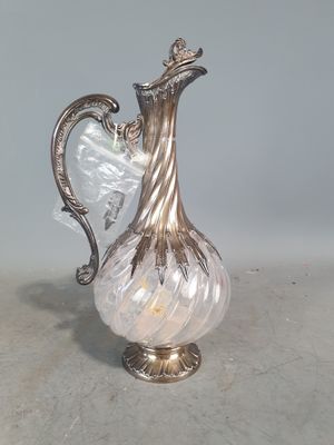 un vase en argent et en verre muni d'une anse, posé sur une table
