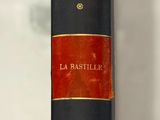 un livre noir et rouge exposé, muni d'une étiquette de prix