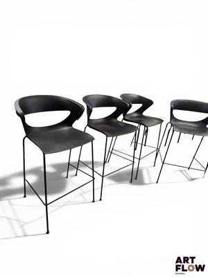 three black chairs sitting next to each other on a white surface