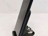 a close up of a cell phone on a stand on a table