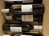 six bottles of wine in a box on the table
