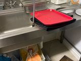 a sink in a kitchen with a red tray on the counter