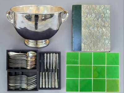 a silver bowl, silverware, and other silverware on a table