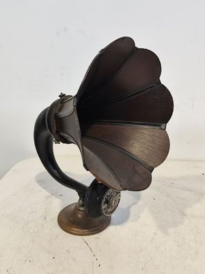 un vieux gramophone posé sur une table, sur fond blanc